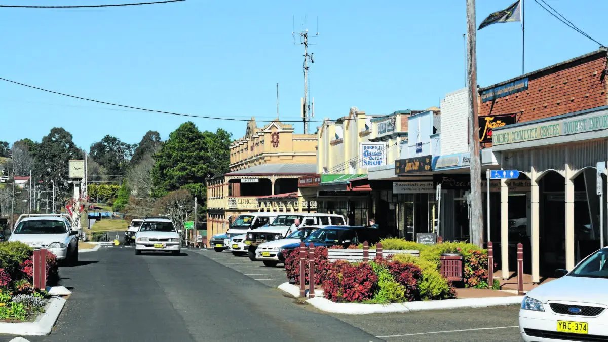 Dorrigo's main street under wide awnings, with mist on the escarpment behind the town
